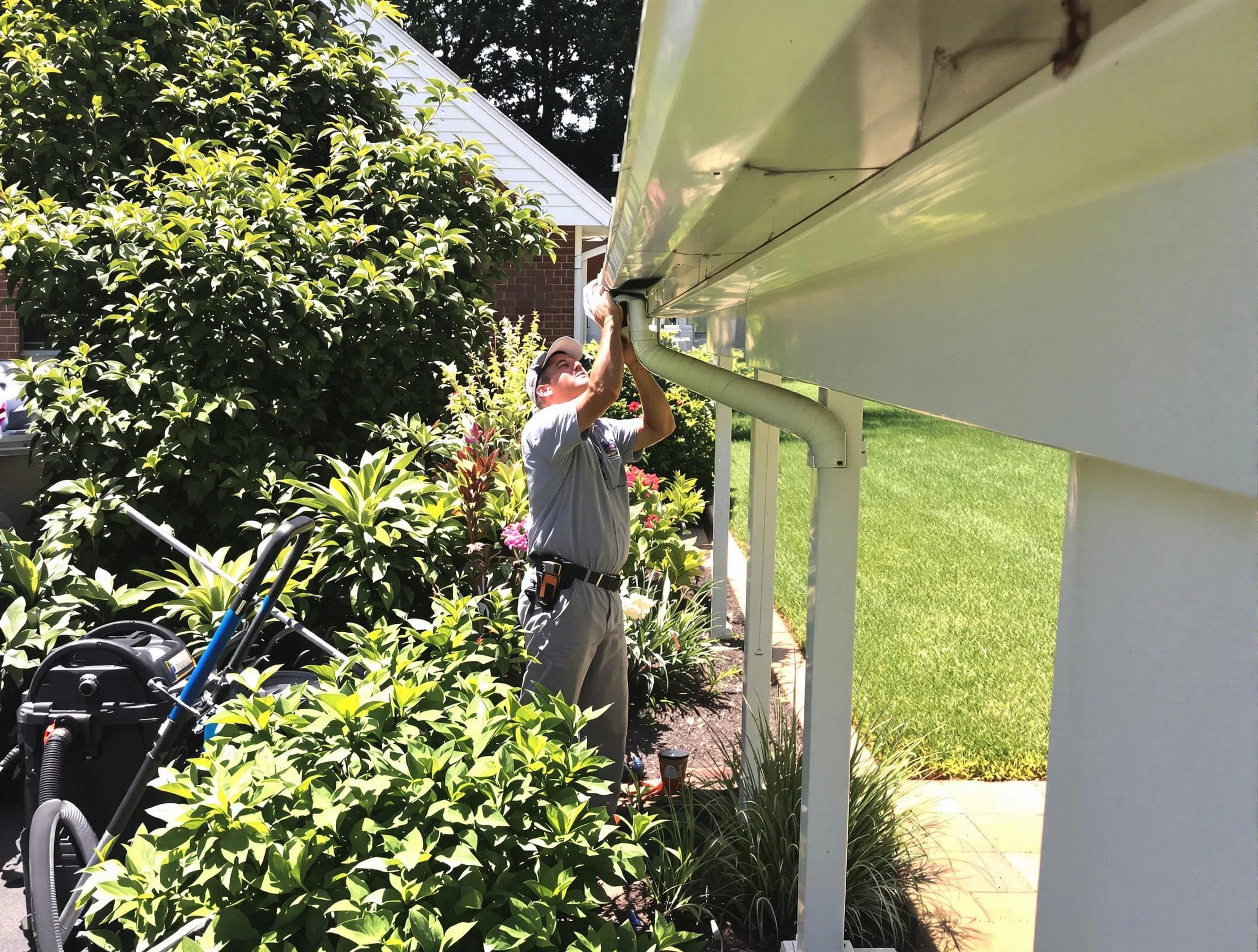 Technician flushing a blockage from a downspout in Cleveland Heights, OH